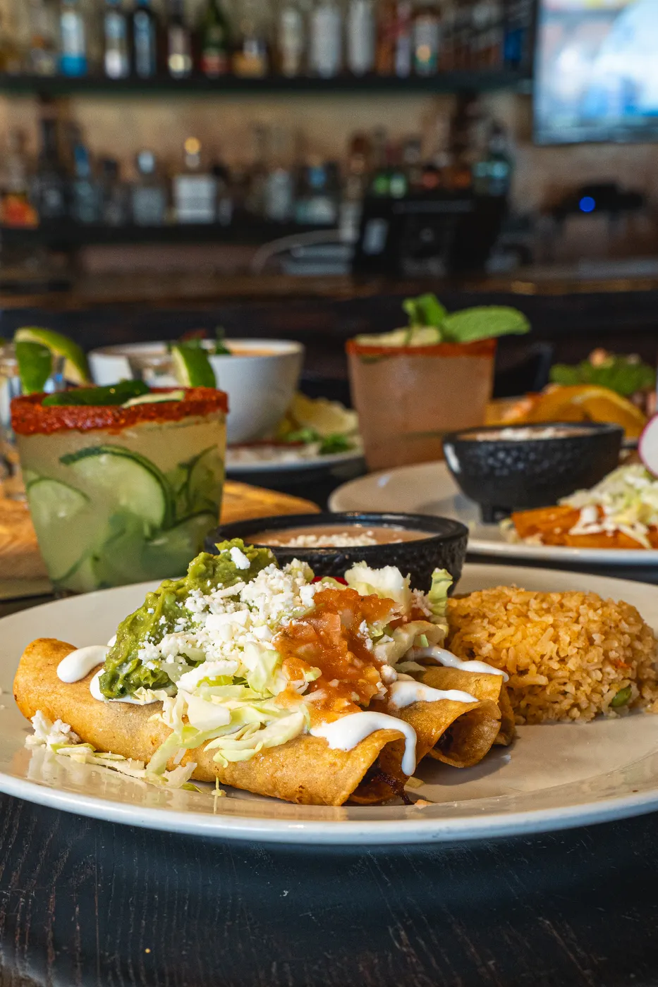 Rolled tacos topped with cotija cheese and shredded cabbage
